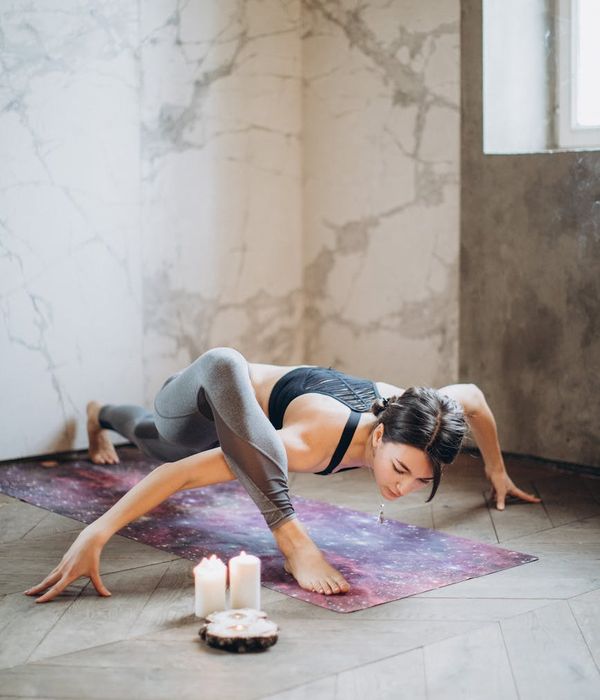 Woman in a graceful yoga pose with aquamarine light accents.